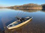 Fishing kayak on a calm lake with trees in the background